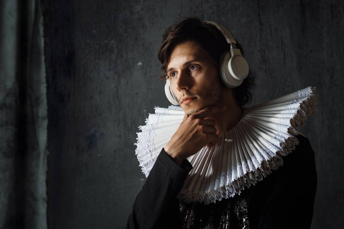 Dressed up man listens to something with his headphones